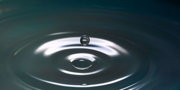 Water droplet creating a ripple effect, symbolizing the lasting impact of coaching